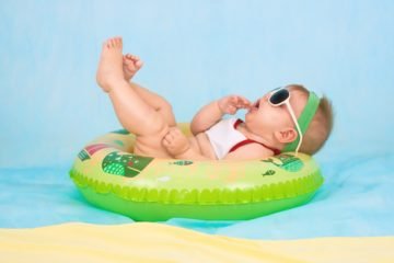 Kind mit Sonnenbrille in Babywanne